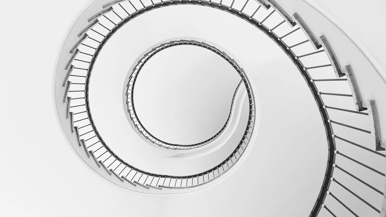 Escalier en colimaçon blanc vu depuis le bas, marches en spirale